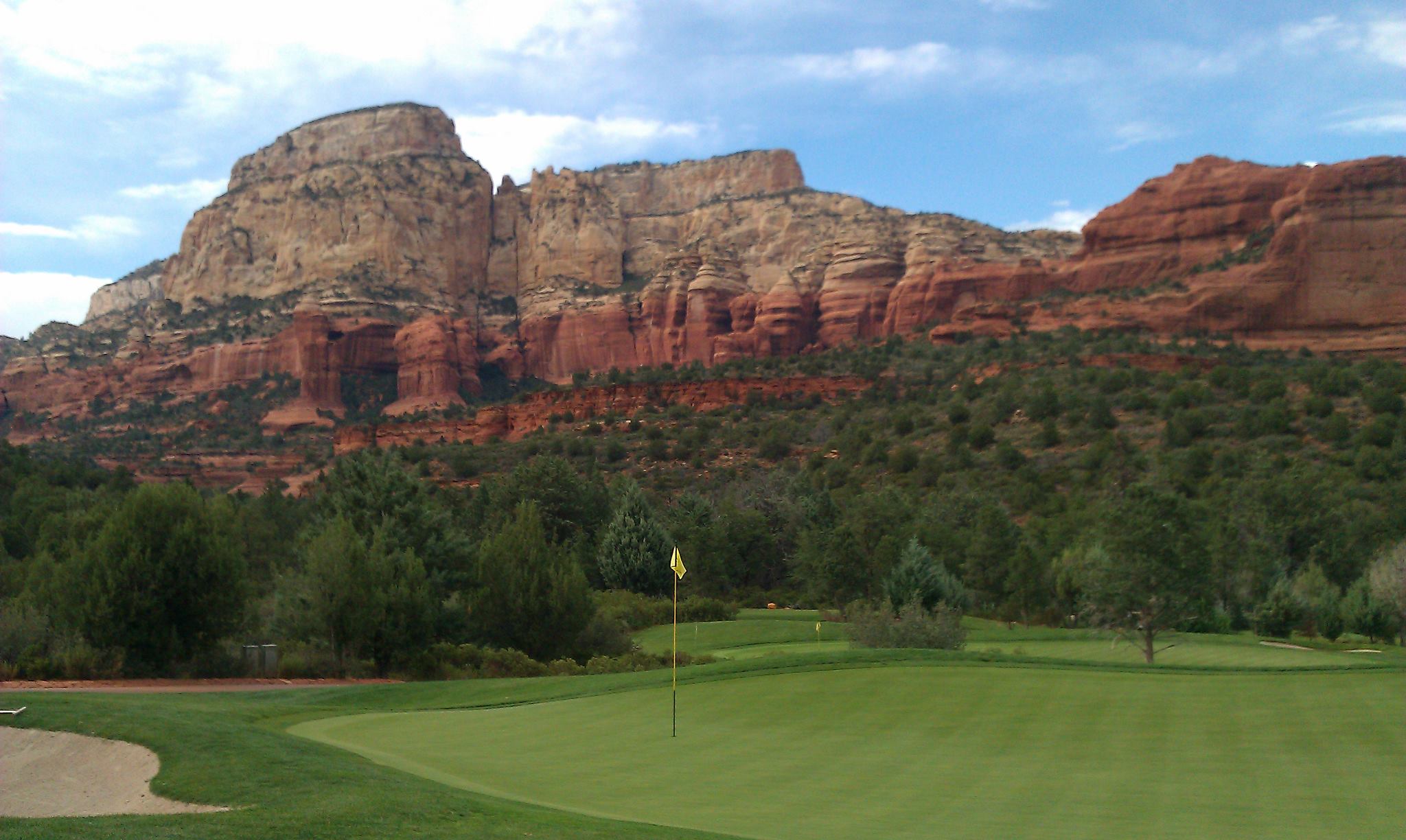 Sedona red rock formations behind a golf green — near Red Rock Suites